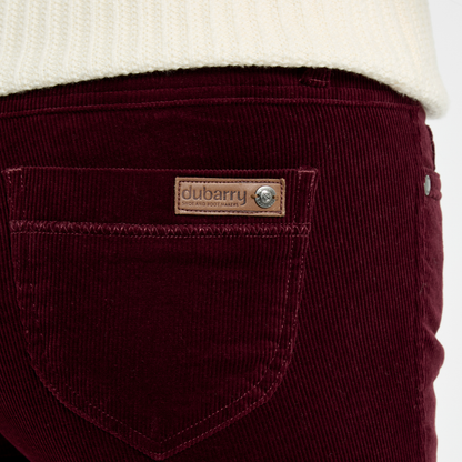 Close-up of Dubarry Honeysuckle Pincord Trousers in Raisin, showing the rear pocket, fine cord texture and leather logo badge.