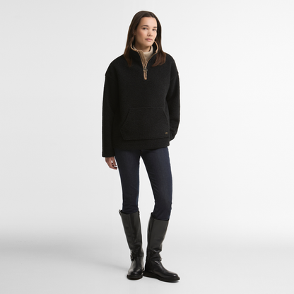 Woman wearing the Barbour Bamburgh Fleece in Black with dark jeans and knee-high black boots.
