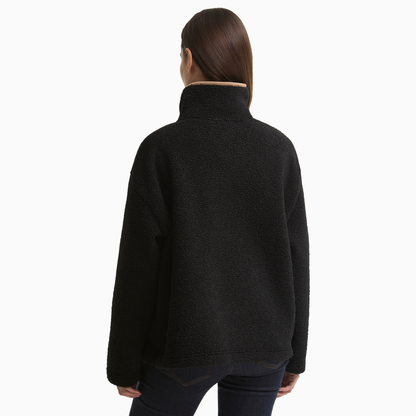 Rear view of a woman wearing the Barbour Bamburgh Fleece in Black, showing the textured fabric and high collar.