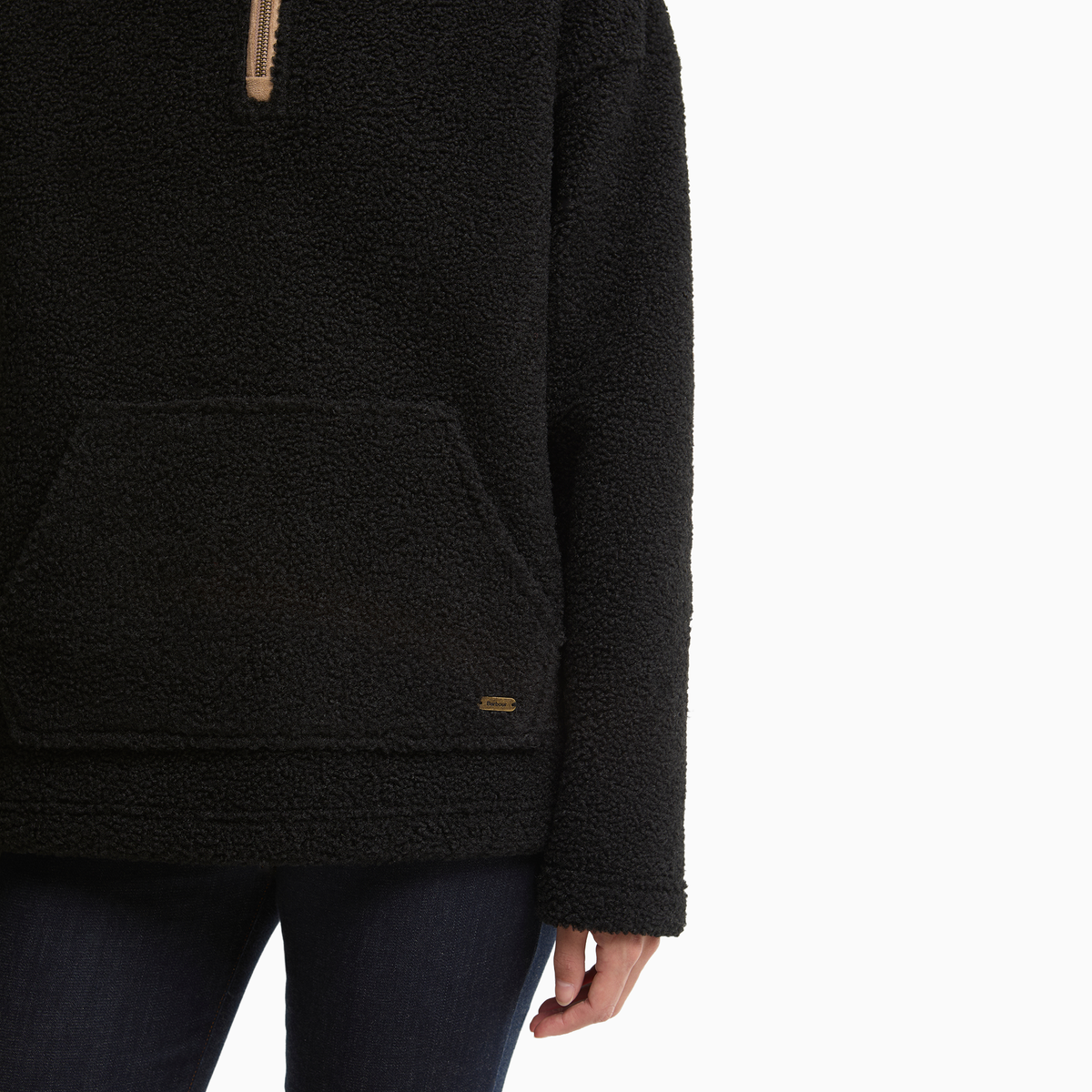 Close-up of the Barbour Bamburgh Fleece in Black, showing the textured fabric, kangaroo pocket and small metal logo badge.