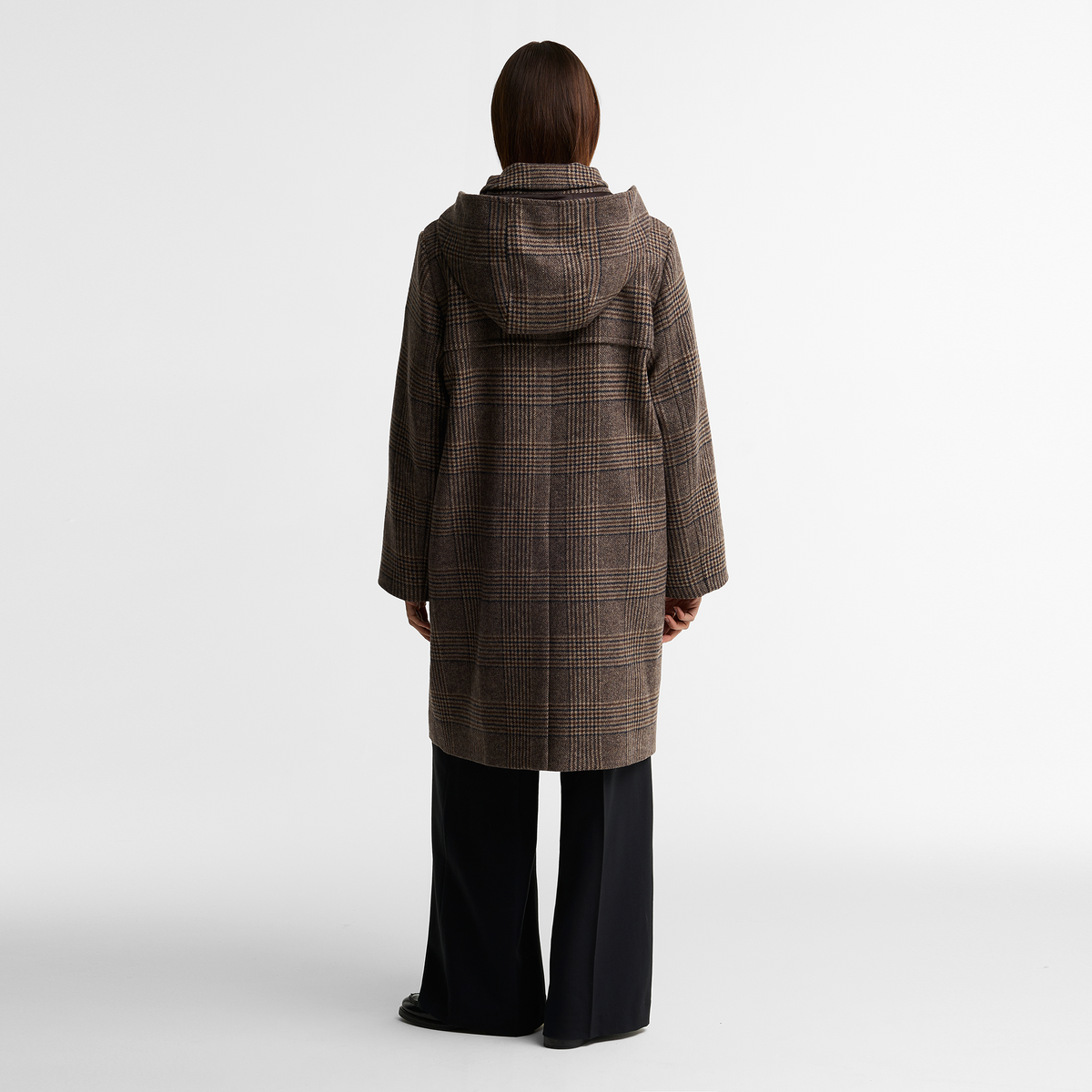 Model viewed from the back wearing the Barbour Melody Check Wool Duffle Coat in brown, showcasing the detachable hood and back vent for ease of movement.