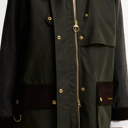 Close-up of the Barbour Kirklees Checked Waxed Jacket in fern green. Featuring brass stud fastenings and a two-way zip. The pockets and cuffs are finished with a brown corduroy trim and the sleeves showcase a checked pattern.